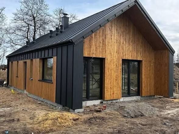 Casă modulară modernă cu fațadă neagră și lemn