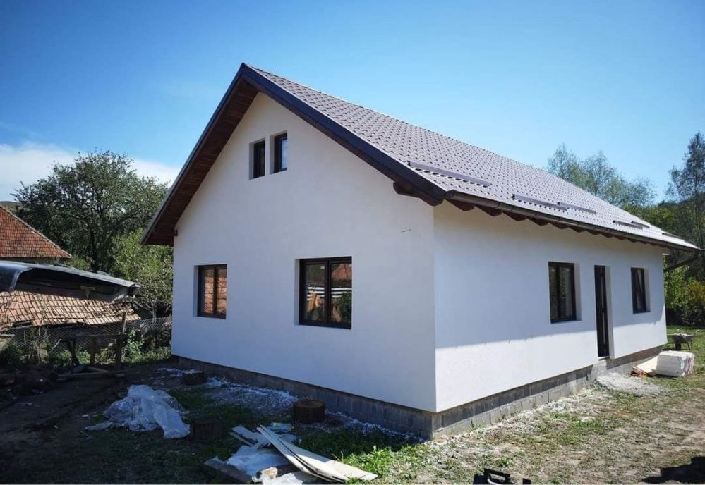 Casă modulară cu tencuială albă și acoperiș țiglă