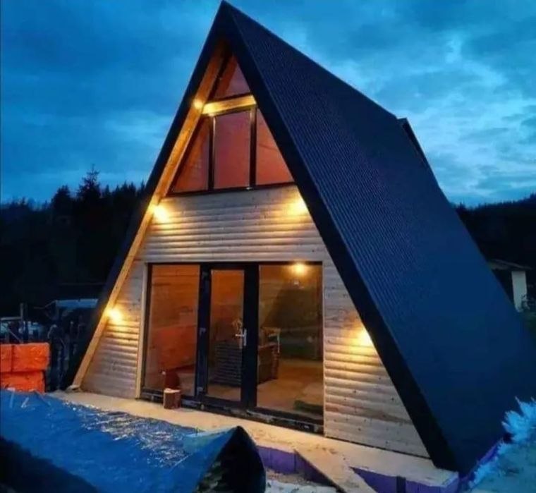 Casă A-Frame seara cu lumini exterioare